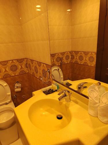 a bathroom with a sink and a toilet and a mirror at كروان لـلشـقق المخدومه حي الفيصلية التحليه Carawan Serviced Apartment ALFAISLIYA Altahliya in Jeddah