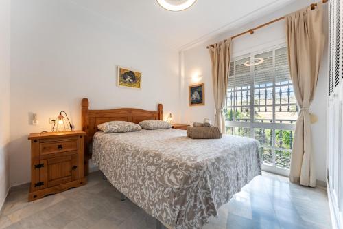 a bedroom with a bed and a large window at Lovely apartment in peaceful area in Mijas