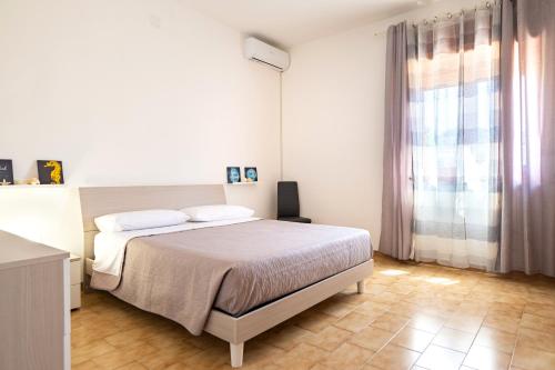 una camera da letto bianca con un letto e una finestra di Villa Bianca a Pulsano