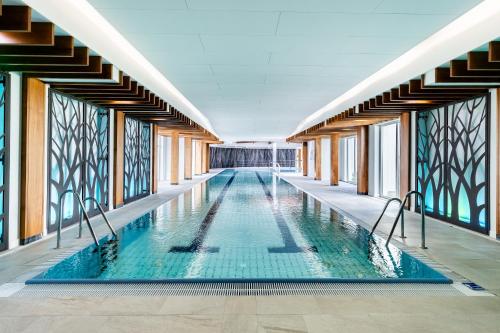 einen Pool in einem Gebäude mit Glasfenstern in der Unterkunft Medica Hotel Krojanty Bory Tucholskie in Chojnice