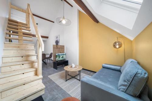 un salon avec un canapé bleu et une table dans l'établissement Le Duplex Moutarde, à Chalon-sur-Saône