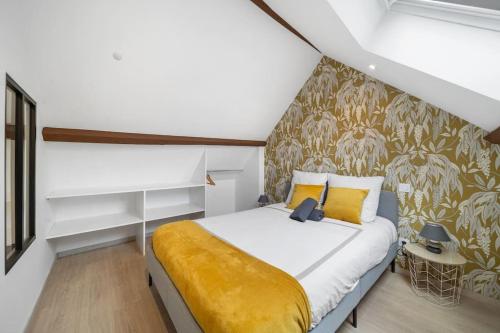 une chambre avec un lit avec une couverture jaune dans l'établissement Le Duplex Moutarde, à Chalon-sur-Saône