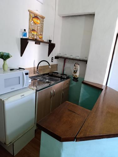 a small kitchen with a stove and a microwave at Residencial María in Bombinhas