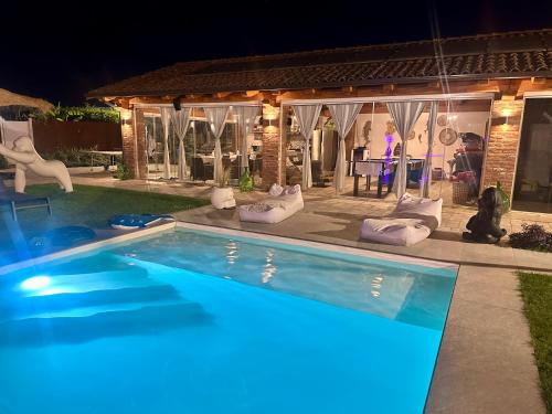 a swimming pool in front of a house at night at Family Relais La Magnolia in Villanova dʼAsti
