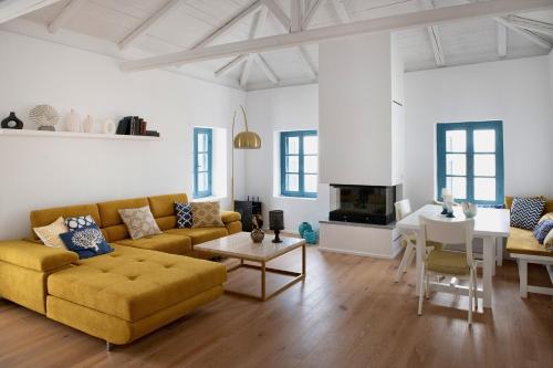 a living room with a yellow couch and a table at PositiveSpace Kalamata Heights in Kalamata