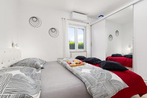 a bedroom with two beds and a mirror at Villa ZaVaLa Brzac in Brzac