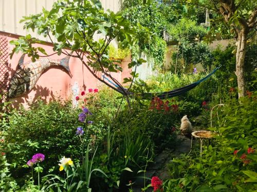 d'un jardin avec des fleurs et un hamac. dans l'établissement Chez Renaud, à Noisy-le-Sec