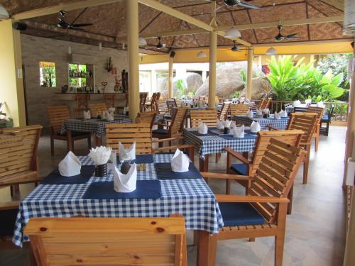 un restaurant avec des tables et des chaises bleues et blanches dans l'établissement Flower Paradise Bungalows & Swiss Restaurant Roestiland, à Lamai