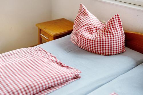 a bed with two red and white pillows on it at Grüner Ausblick in Oberkirch
