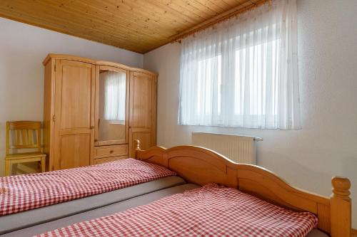 a bedroom with two beds and a cabinet and a window at Grüner Ausblick in Oberkirch