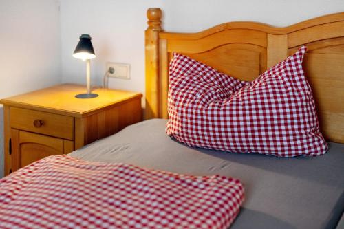 a bed with two red and white pillows on it at Grüner Ausblick in Oberkirch