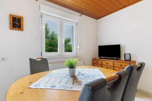 a dining room with a table and a tv at Grüner Ausblick in Oberkirch
