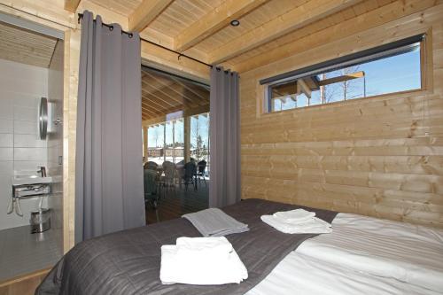Un dormitorio con una cama y una ventana grande. en Eerikkilä Sport & Outdoor Resort, en Tammela