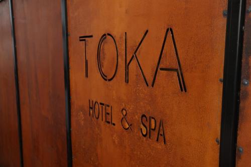 a wooden door with the words toka written on it at Toka Hotel Restaurant in Pogradec