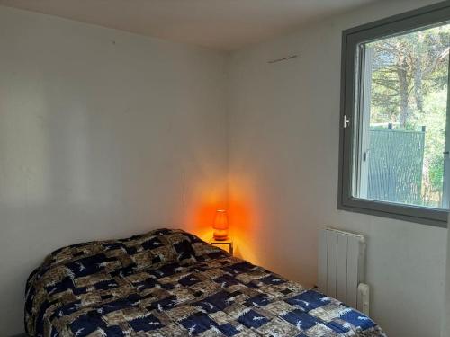 - une chambre avec un lit et une lampe à côté d'une fenêtre dans l'établissement CAP proche naturiste, au Cap d'Agde