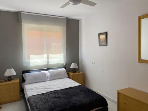 1 dormitorio con 1 cama con ventana y 2 mesitas de noche en Central Puerto, en Puerto de Mazarrón
