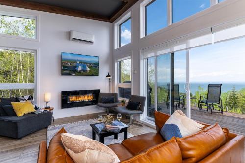 a living room with a couch and a fireplace at Oasis by the River in Saint-Irénée