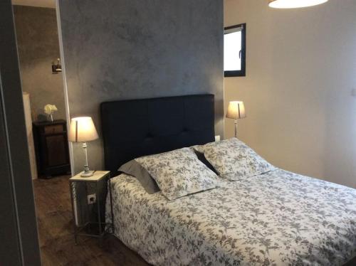 une chambre avec un grand lit avec deux lampes dans l'établissement Maison entière location tourisme quatre étoiles proche de sites touristiques, à Le Roc