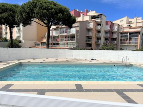 une grande piscine devant un immeuble dans l'établissement Studio cosy, 2 pers, proche port, plages et centre, Cap d'Agde - FR-1-249-365, au Cap d'Agde