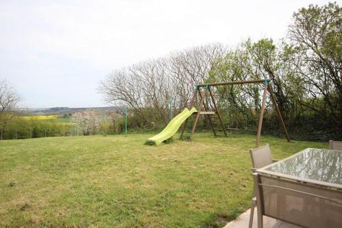une aire de jeux avec toboggan jaune dans un champ dans l'établissement Chez Marie-Anne, à Sacquenay