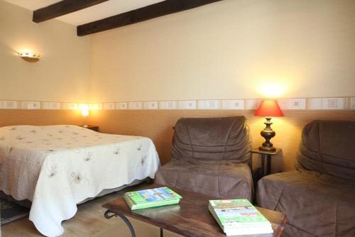 a room with two chairs and a bed and a table at Chez Marie-Anne in Sacquenay
