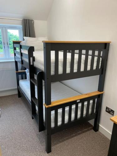 two black bunk beds in a room with a window at Newly Converted Barn in Kings Bromley