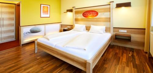 a bedroom with a large white bed in a room at Revita Hotel Kocher in Sankt Agatha