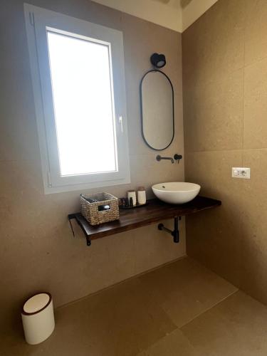 a bathroom with a sink and a window at Acqua Salmastra Apartment in Favignana