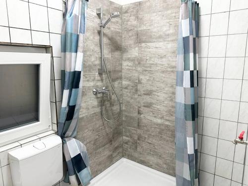ein Bad mit einer Dusche und einem TV in der Unterkunft Work and Stay Apartment in Troisdorf in Troisdorf
