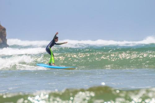 a person riding a wave on a surfboard in the ocean at Duplex Oualidia surfhouse in Oualidia