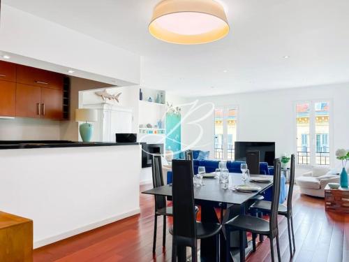 une salle à manger et une cuisine avec une table et des chaises dans l'établissement Le Félix Faure - Palais Centre Cannes, à Cannes