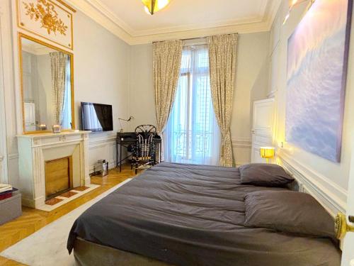 - une chambre avec un grand lit et une cheminée dans l'établissement L'appartement Vendome, à Paris