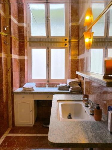 une salle de bain avec un lavabo et une fenêtre dans l'établissement L'appartement Vendome, à Paris