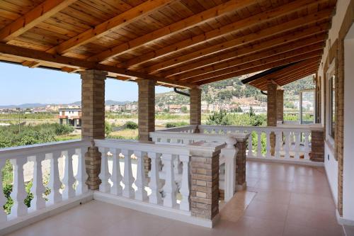 a balcony with white railings and a wooden ceiling at Villa Lejzo - Swimming Pool in Berat