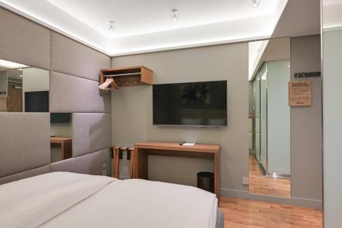 a bedroom with a bed and a tv on the wall at Comfort Hotel Xpress Helsinki Airport Terminal in Vantaa