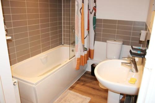 a bathroom with a sink and a tub and a toilet at Bowery Apartment - 2 Bedrooms 1st floor in Dagenham