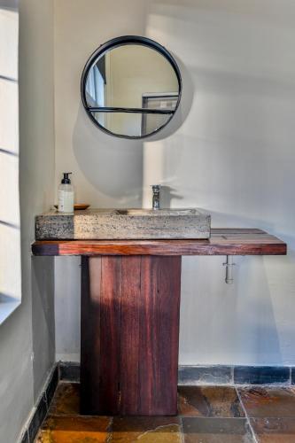 a bathroom counter with a mirror and a sink at Blue Rain Guest House in Bloemfontein