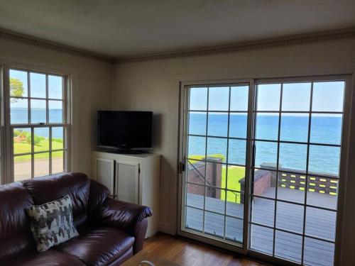 a living room with a couch and a view of the ocean at On the Water Spacious Comfortable Historic House in West Haven