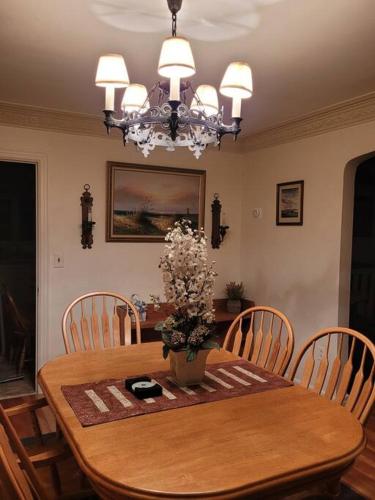 a dining room table with a vase of flowers on it at On the Water Spacious Comfortable Historic House in West Haven
