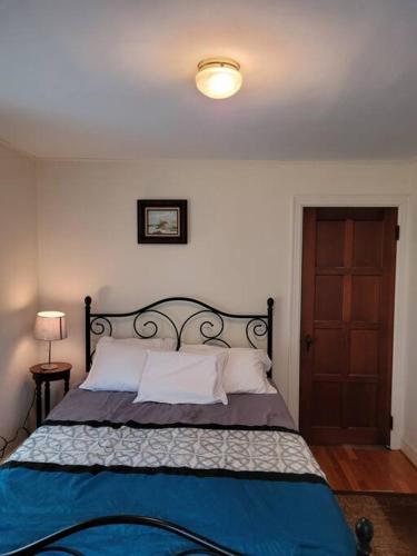 a bedroom with a bed with a blue blanket and a door at On the Water Spacious Comfortable Historic House in West Haven