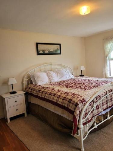 a bedroom with a bed and two night stands with lamps at On the Water Spacious Comfortable Historic House in West Haven