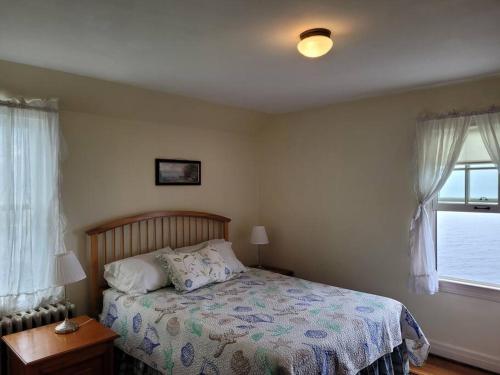 a bedroom with a bed and a window at On the Water Spacious Comfortable Historic House in West Haven