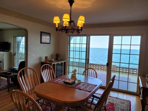a dining room with a table and a view of the ocean at On the Water Spacious Comfortable Historic House in West Haven