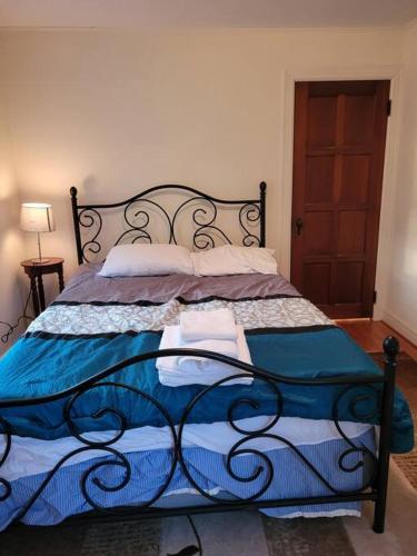 a bedroom with a bed with a blue and white blanket at On the Water Spacious Comfortable Historic House in West Haven