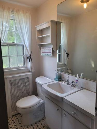 a white bathroom with a toilet and a sink at On the Water Spacious Comfortable Historic House in West Haven