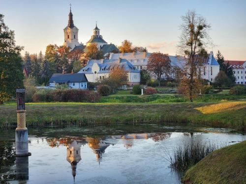 a small village with a church and a pond at Dom Pielgrzyma w Kodniu in Kodeń