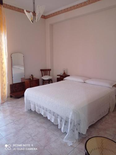 a bedroom with a white bed and a chair at Montagne Rocciose in Frascineto