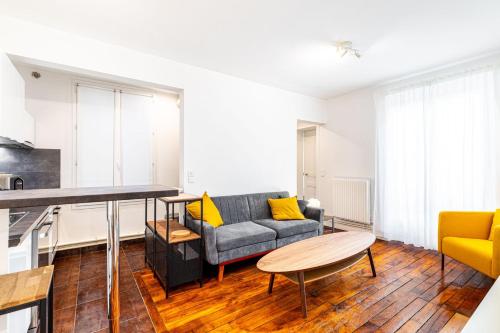 un salon avec un canapé et une table dans l'établissement GuestReady - Appartement Confortable dans le 10e., à Paris