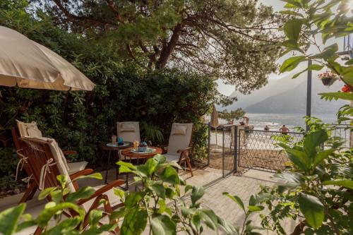 a patio with chairs and an umbrella and the ocean at Stone sea apartment in Risan