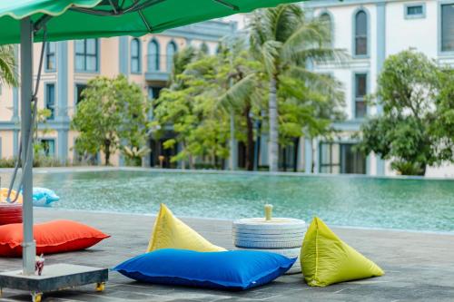 un gruppo di cuscini su un tavolo accanto a una piscina di Minimalist & Modern Apartment III a Phu Quoc